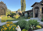 Colorful flower beds and ornamental grasses in front of a stone home